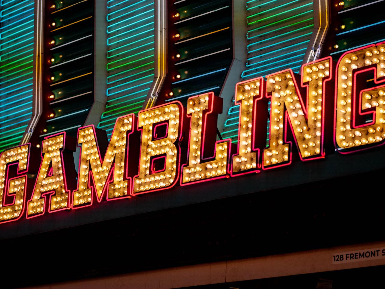 Bright neon sign displaying 'Gambling' with vibrant lights at night in Las Vegas.
